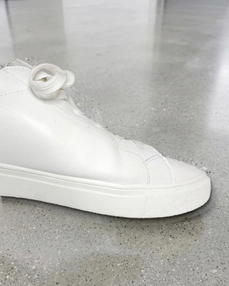 After: the same white sneaker with a clean, bright white midsole following one Tread Logic wipe
